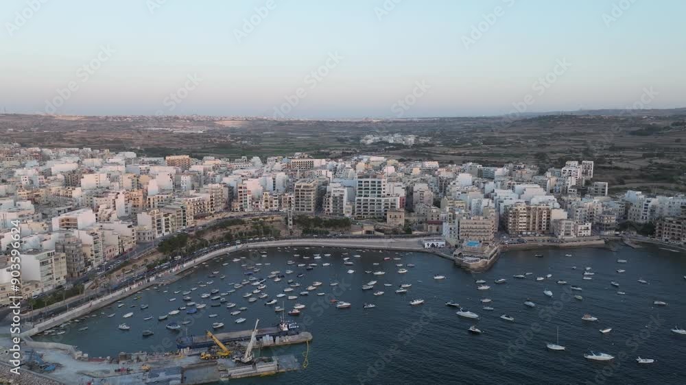 Boats At Bugibba Bay Marina In St. Paul's Bay Town With Seafront Buildings In Malta. - aerial shot Boats At Bugibba Bay Marina In St. Paul's Bay Town With Seafront Buildings In Malta. - aerial shot