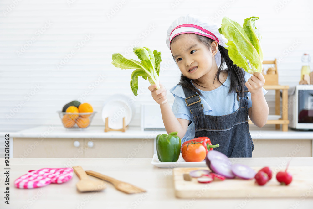 asian kid holding vegetables and preparing meal in the kitchen asian kid holding vegetables and preparing meal in the kitchen