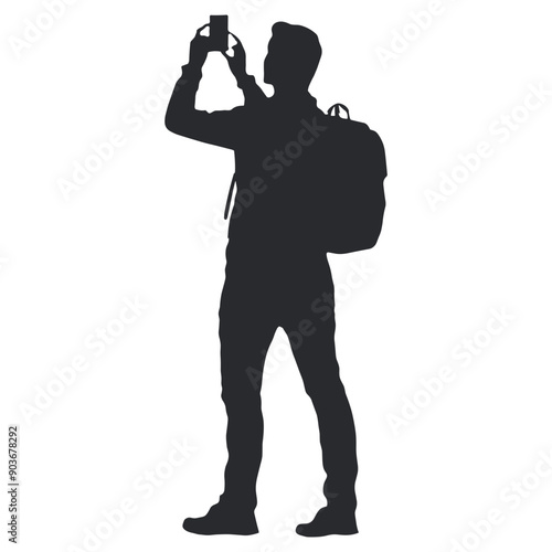 Silhouette of a man with a backpack taking a photo.