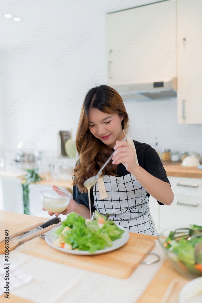 Young asian woman use spoon to adding mayonnaise into salad on plate while preparing fresh vegetables salad in bowl and cooking healthy breakfast food in modern kitchen with healthy lifestyle at home Young asian woman use spoon to adding mayonnaise into salad on plate while preparing fresh vegetables salad in bowl and cooking healthy breakfast food in modern kitchen with healthy lifestyle at home