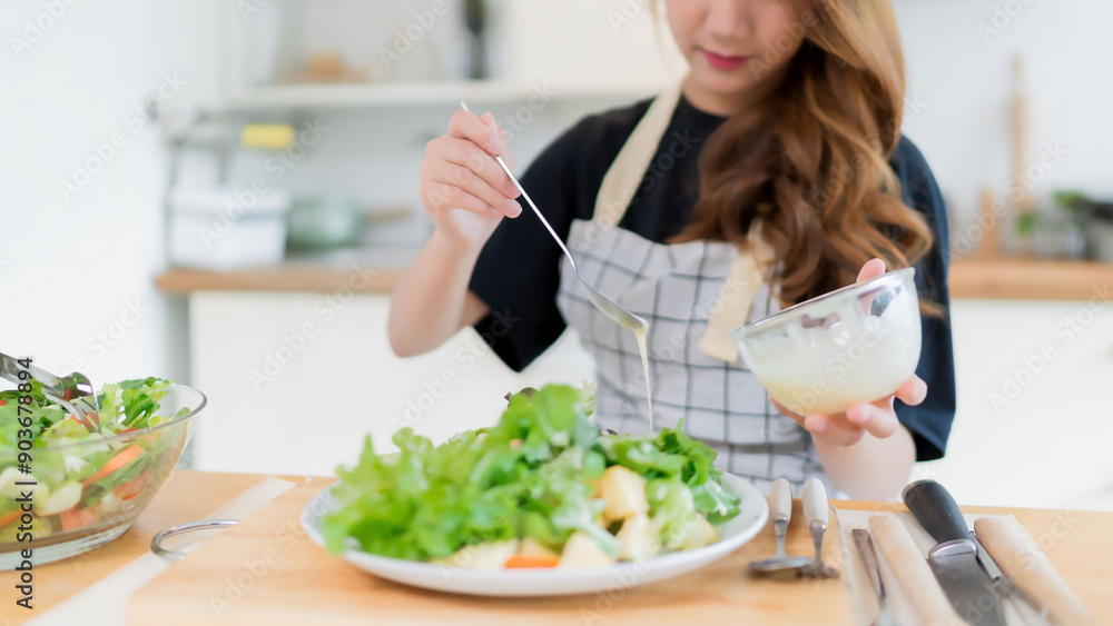 Young asian woman use spoon to adding mayonnaise into salad on plate while preparing fresh vegetables salad in bowl and cooking healthy breakfast food in modern kitchen with healthy lifestyle at home Young asian woman use spoon to adding mayonnaise into salad on plate while preparing fresh vegetables salad in bowl and cooking healthy breakfast food in modern kitchen with healthy lifestyle at home