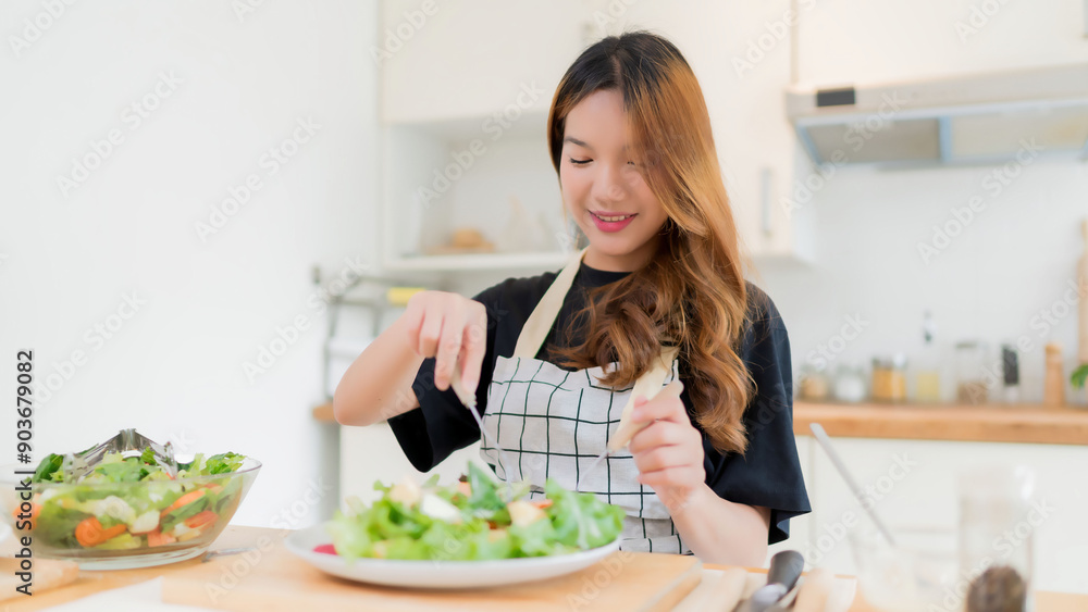 Young asian woman enjoying to eating vegetables salad after mixing fresh vegetables salad with dressing in bowl and cooking healthy breakfast food in modern kitchen with healthy lifestyle at home Young asian woman enjoying to eating vegetables salad after mixing fresh vegetables salad with dressing in bowl and cooking healthy breakfast food in modern kitchen with healthy lifestyle at home