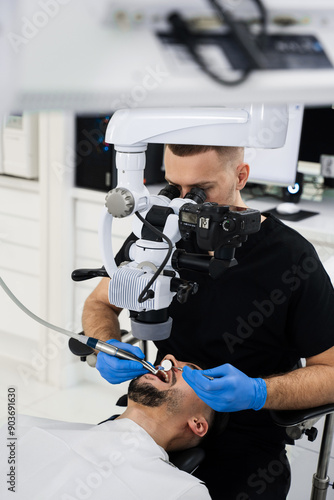 Fotografie Dentist uses operating microscope to polish teeth of the patient