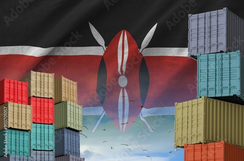 Kenya flag and big stack of shipping cargo containers in docks with sky background close up photo