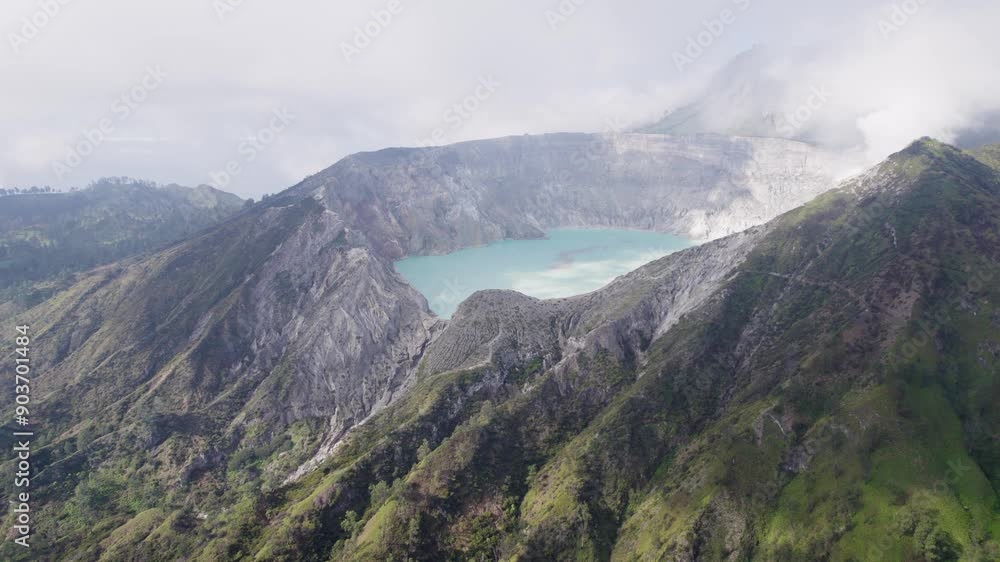 Aerial Circling The Rim Of A Steaming Volcano Ijen with a Turquoise Lake, and foggy cloudy Mountain in the background - East Java, Indonesia Aerial Circling The Rim Of A Steaming Volcano Ijen with a Turquoise Lake, and foggy cloudy Mountain in the background - East Java, Indonesia