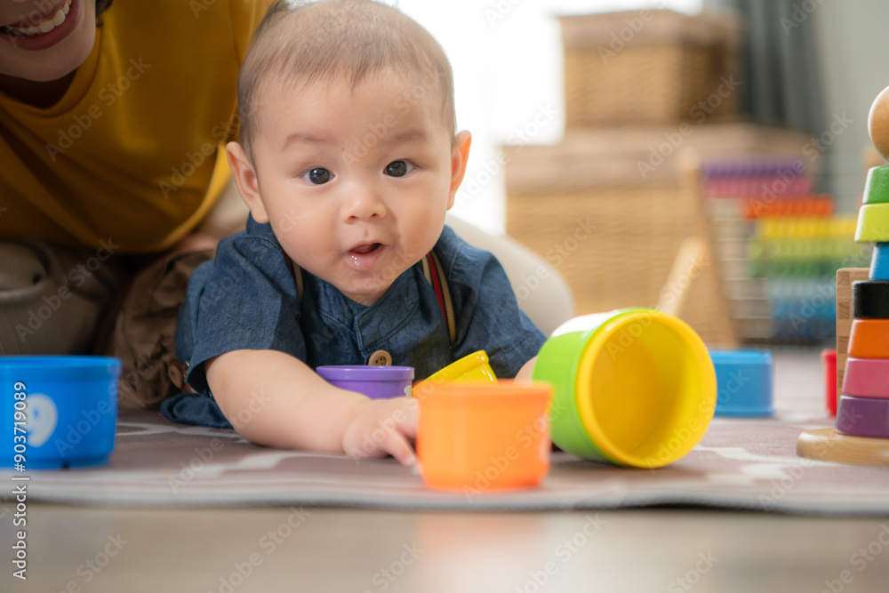 A tiny child cheerfully plays with toys on the floor of the living room with mom A tiny child cheerfully plays with toys on the floor of the living room with mom