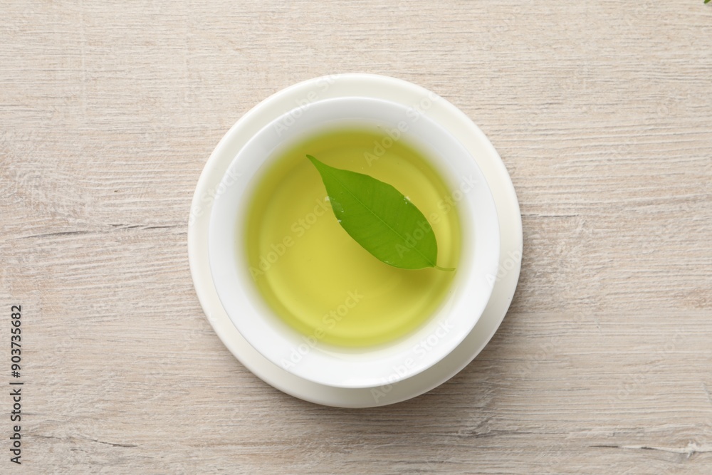 Refreshing green tea in cup on wooden table, top view Refreshing green tea in cup on wooden table, top view