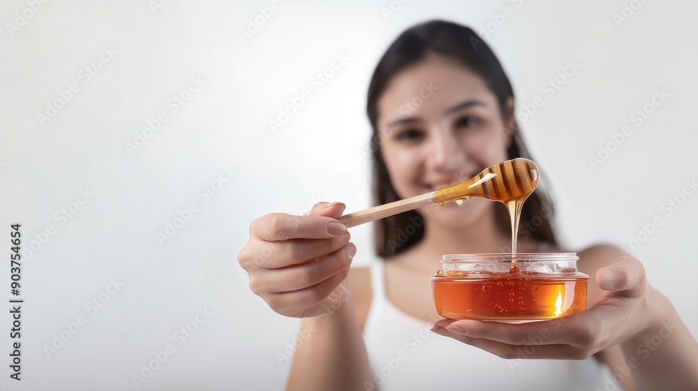 Woman applying wax with a wooden stick pouring wax from a glass bowl white background, hair removal process, wax application, beauty treatment Woman applying wax with a wooden stick pouring wax from a glass bowl white background, hair removal process, wax application, beauty treatment