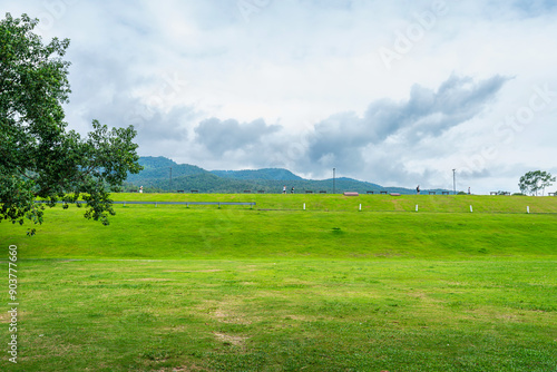 beautiful landscape green grass with in nature forest Mountain views spring with air atmosphere bright blue sky background abstract clear background texture with white clouds.