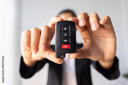 Wallpaper Mural Close up of woman hand holds the car key isolated on a white Blurred background  Torontodigital.ca