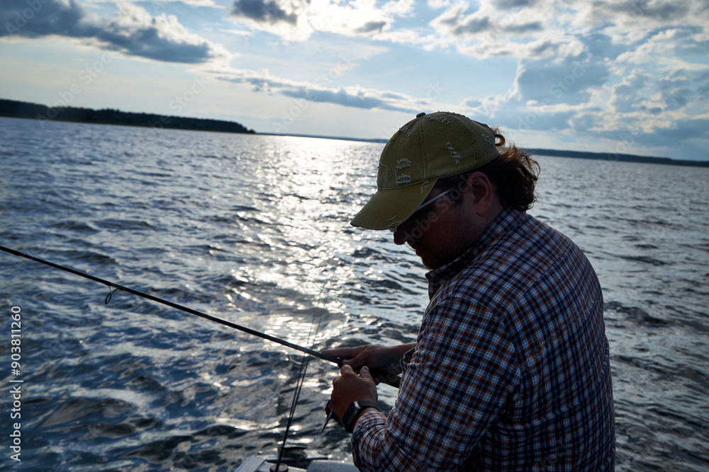 Obraz premium a man in a plaid shirt fishing out of a boat