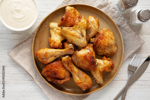 Homemade BBQ Chicken Drumsticks and Wings with Alabama White Sauce, top view.