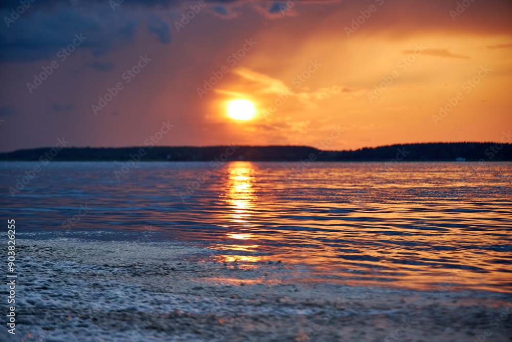 Obraz premium blurred background view of summer sunset with the reflection of the sun on the river