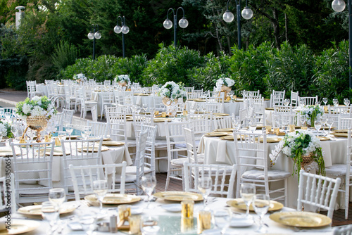 Obraz na płótnie Elegant outdoor wedding reception with white chairs and floral centerpieces w salonie