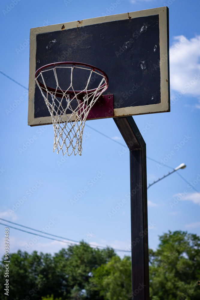 Color vertical photo, metal net on basketball hoop close-up with cityscape, sky background in park. Color vertical photo, metal net on basketball hoop close-up with cityscape, sky background in park.