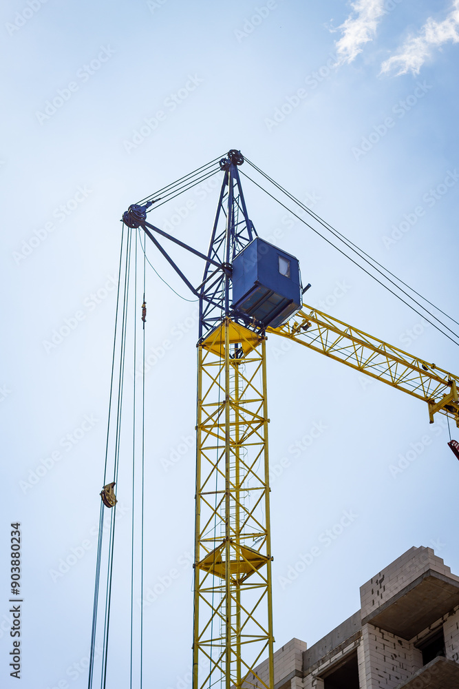 A tower crane at a house construction site. A tower crane at a house construction site.