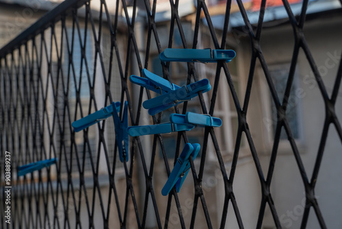 a lot of blue clothespins are attached to a metal grid. Blue clothespins for drying clothes. High quality photo
