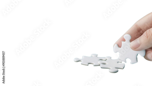 A hand holding a jigsaw puzzle piece. Concept of solving a puzzle, which can be a metaphor for overcoming challenges or finding solutions to problems. Scene is focused and determined