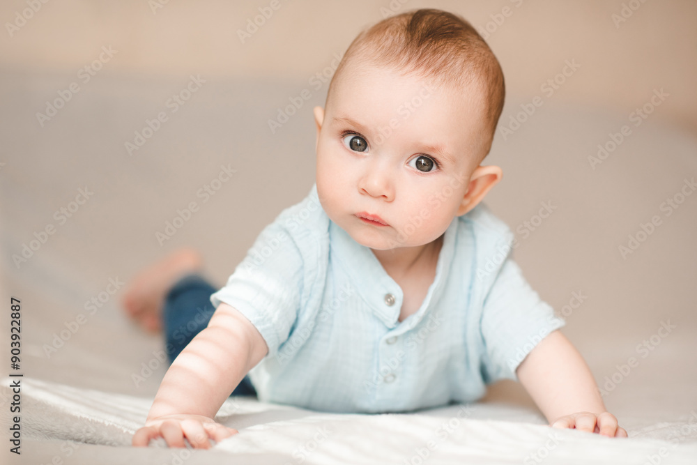 Funny baby boy 4-5 months old frowning crawling in bed close up. Looking at camera. Childhood. Funny baby boy 4-5 months old frowning crawling in bed close up. Looking at camera. Childhood.