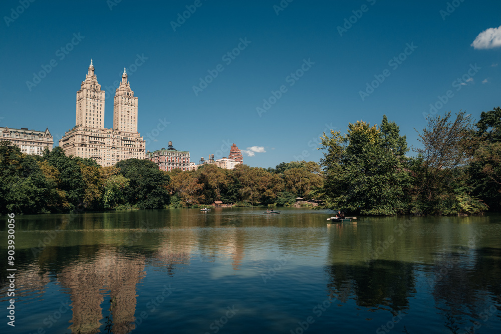 View of modern tall buildings, trees and blue lake in New York City's Central Park, Manhattan on a summer day View of modern tall buildings, trees and blue lake in New York City's Central Park, Manhattan on a summer day