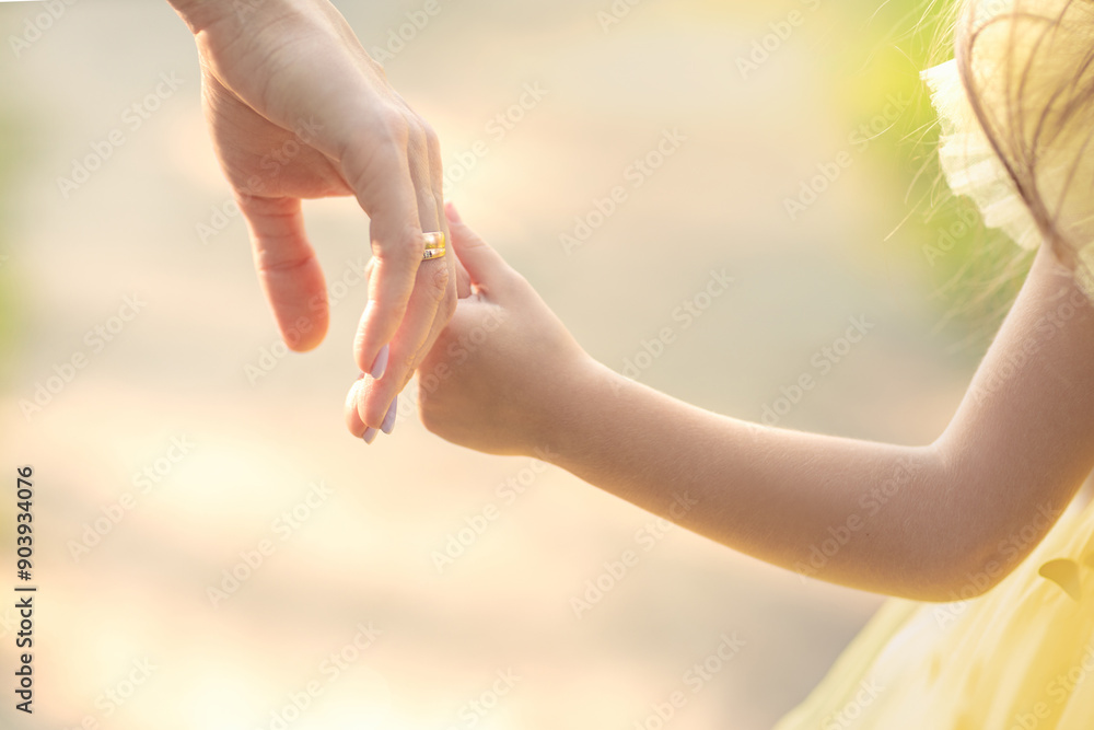 mom holds her daughter's hand outdoors on a sunny day, adopt a child, foster parenting concept mom holds her daughter's hand outdoors on a sunny day, adopt a child, foster parenting concept
