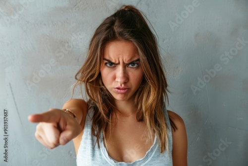 woman with angry expression looking at camera and pointing with index finger in accusatory way Isolated photo