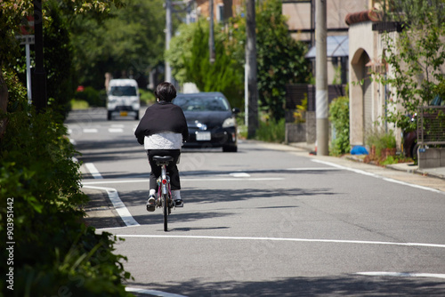 Wallpaper Mural 夏の街の道路で自転車を乗る女性の姿 Torontodigital.ca
