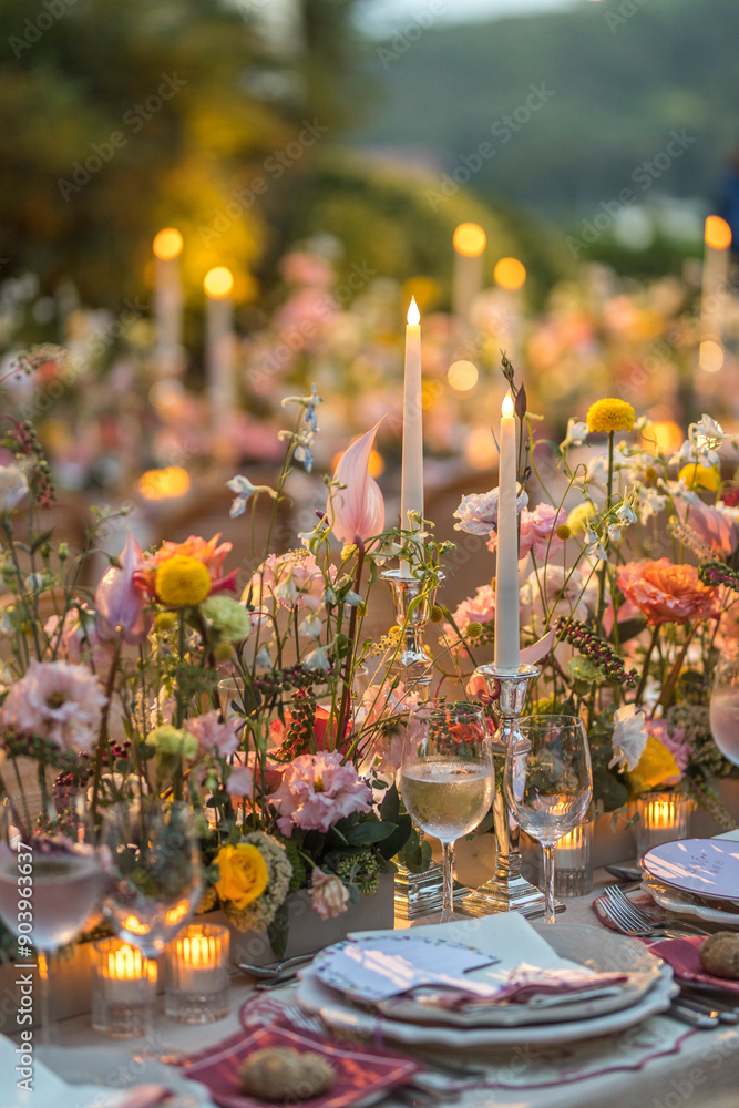 Vibrant outdoor wedding table setting with colorful floral arrangements