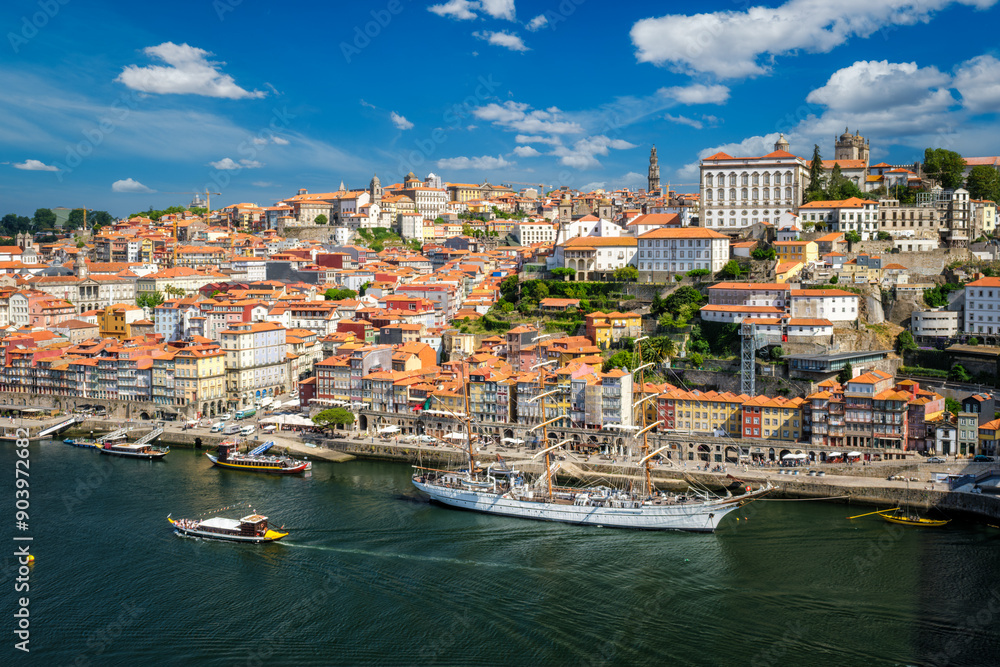 Obraz premium Aerial view of Porto city and Douro river with moored sailling ship from Dom Luis I bridge. Porto, Portugal