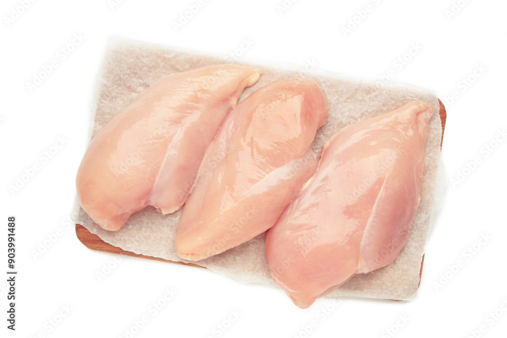 Raw chicken fillet on a cutting board isolated on white background. Top view Raw chicken fillet on a cutting board isolated on white background. Top view
