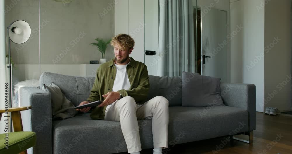 A man in casual clothes uses a tablet, then he opens the front door and takes the box from the delivery guy. Daylight A man in casual clothes uses a tablet, then he opens the front door and takes the box from the delivery guy. Daylight