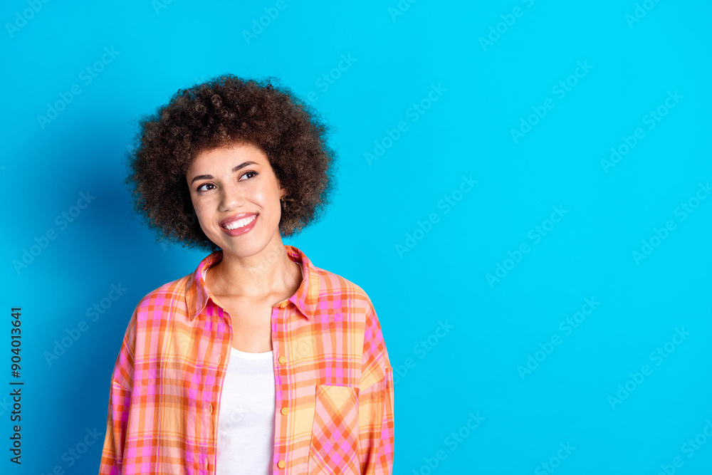 Photo portrait of lovely young lady look empty space dressed stylish checkered garment isolated on blue color background Photo portrait of lovely young lady look empty space dressed stylish checkered garment isolated on blue color background