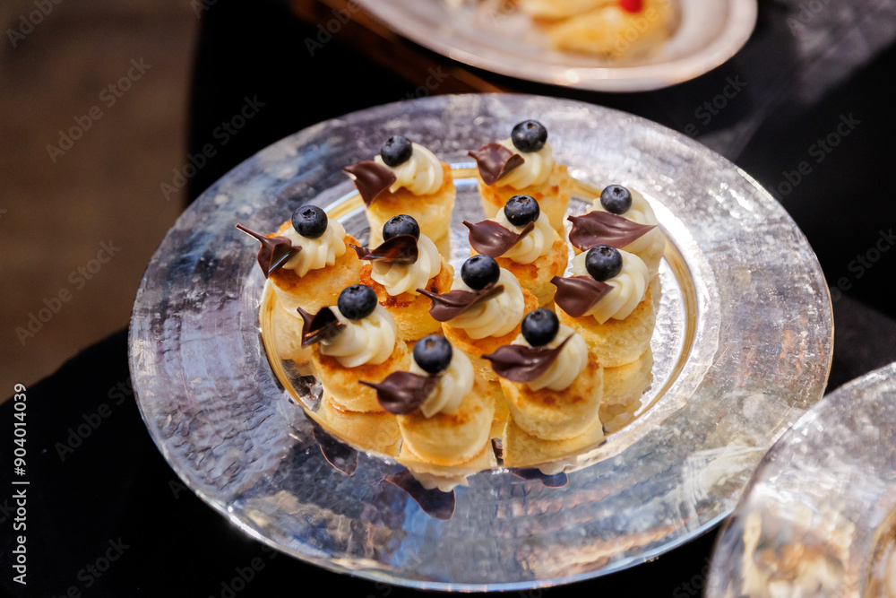 Elegant Dessert Plate: Small Pancakes with Cream, Blueberries, and Chocolate Decor