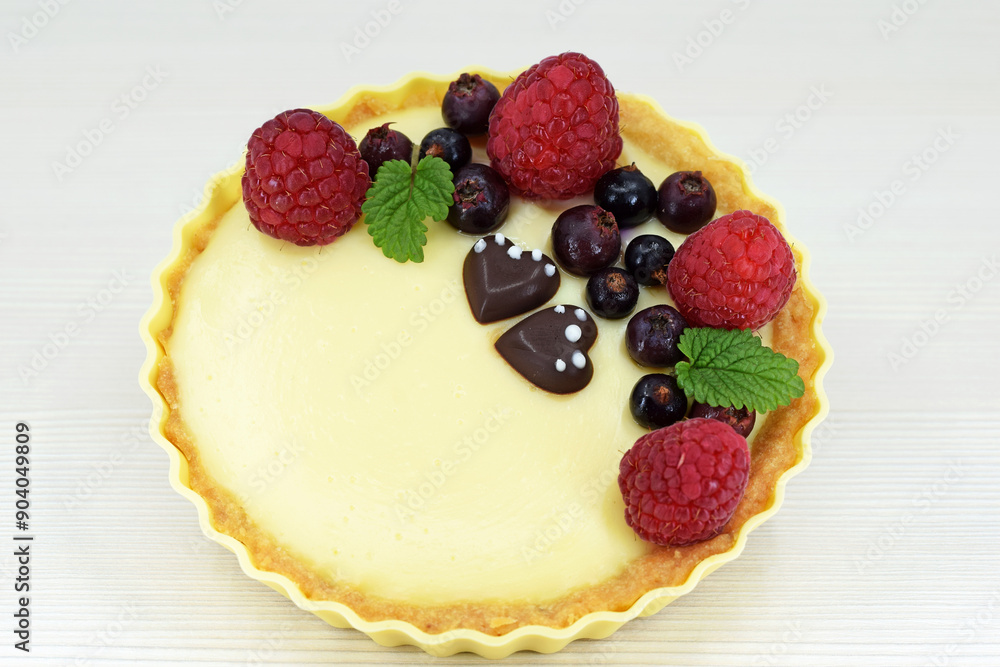 Shortbread vanilla tartlet with fruits, two chocolate hearts and lemon balm leaves Shortbread vanilla tartlet with fruits, two chocolate hearts and lemon balm leaves