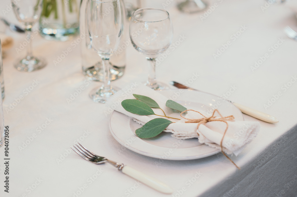 Table setting with napkin on empty white plate, wineglasses and cutlery on table, copy space. Place setting at wedding reception. Table served for banquet Table setting with napkin on empty white plate, wineglasses and cutlery on table, copy space. Place setting at wedding reception. Table served for banquet
