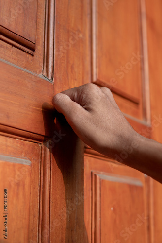 Foto Close up of a man's hand knocking on the door