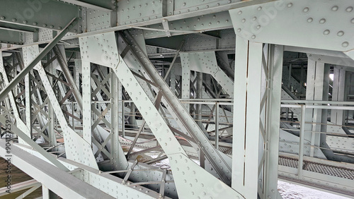 Ancient iron bridge structure, interior view, metal floor beams with rivets photo