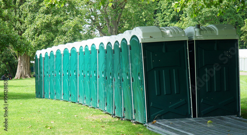 Foto Row of Portaloo in park on grass sunny day