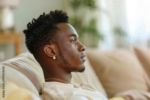 Portrait of a Man Struggling with Depression Sitting on a Sofa Lost in Thought