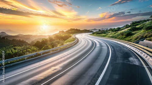 A picturesque winding road at sunset, stretching through lush green hills with a vibrant sky, perfect for travel and adventure themes. © Suwanlee