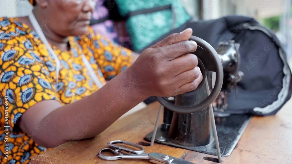 Close-up of an african woman using manual sewing machine Close-up of an african woman using manual sewing machine