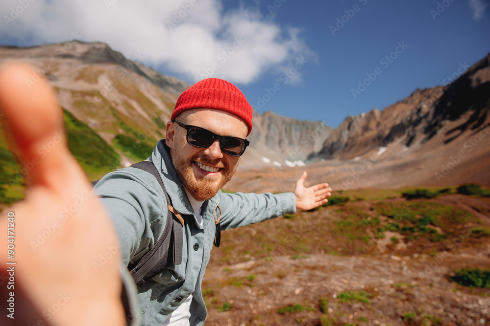 Tourist hipster man on Vachkazhets volcano background make selfie photo on action camera Kamchatka Russia Tourist hipster man on Vachkazhets volcano background make selfie photo on action camera Kamchatka Russia