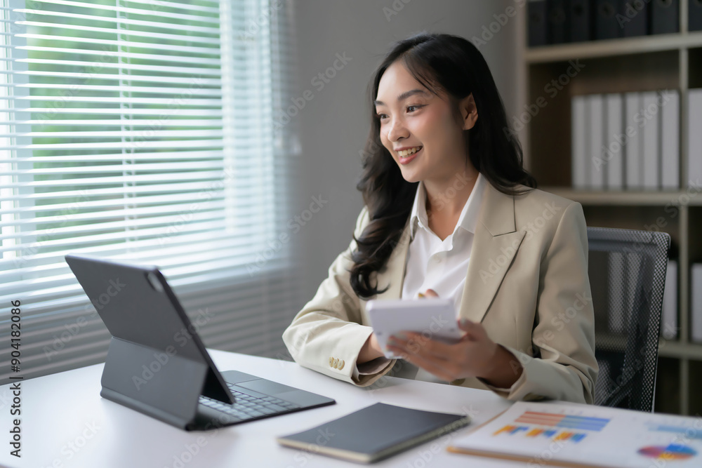 Professional Businesswoman Working on Tablet in Modern Office with Natural Light Professional Businesswoman Working on Tablet in Modern Office with Natural Light