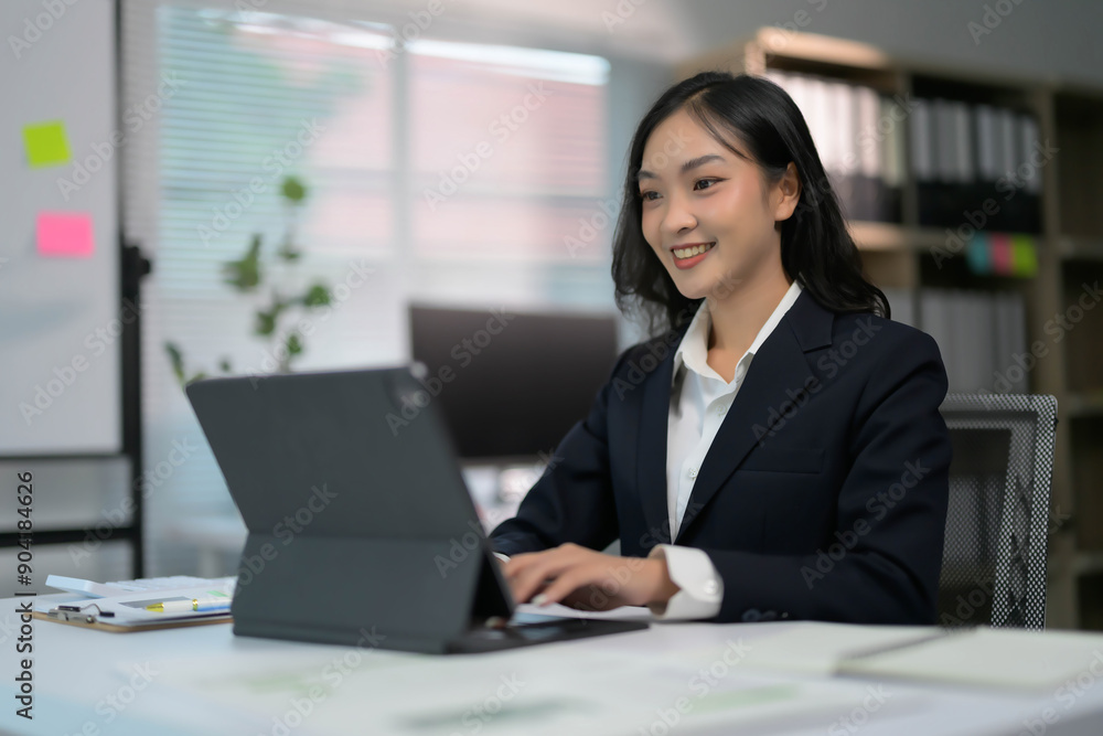Professional Businesswoman Working on Tablet in Modern Office Setting with Natural Light Professional Businesswoman Working on Tablet in Modern Office Setting with Natural Light