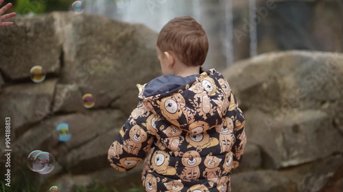 Criança em um parque brincando com bolhas de sabão  photo