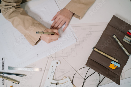 Fotografie The architect carefully sketches a detailed design drawing by hand, shaping the blueprint for a significant architecture project, blending business acumen with engineering precision