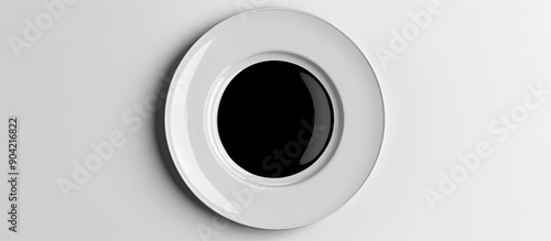 A white background copy space image displays a ceramic plate with a black circle in the center accentuating its emptiness isolated with a clipping path