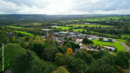 Aerial footage moves closer to a UK chemical factory, highlighting pipes, metal constructions, cooling towers, and chemical storage. photo