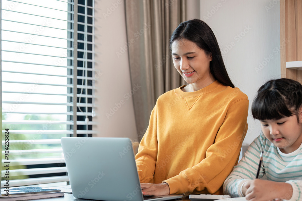 Mother and Child Working from Home Together in a Modern Home Office Setting with Laptop and Study Materials Mother and Child Working from Home Together in a Modern Home Office Setting with Laptop and Study Materials