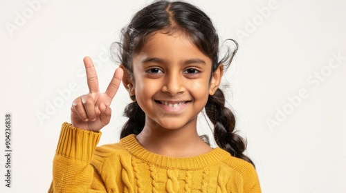 Adorable Indian Asian girl making an OK gesture, cheerful and excited